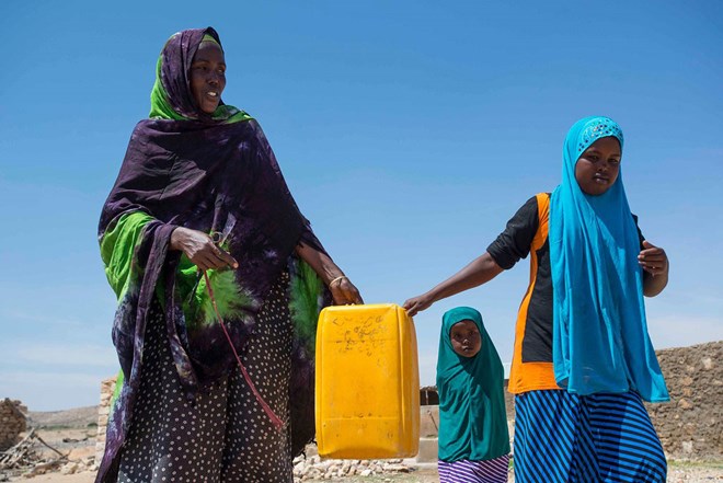 A resident of Rabaable village in Somalia fetches water with the help of her daughters. The villages well was recently rehabilitated by UNICEF. Photo: UNICEF Somalia/Sebastian Rich